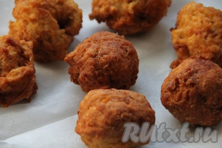 Готовые яблочные пончики достаём из фритюра и выкладываем на бумажную салфетку, чтобы убрать лишнее масло.