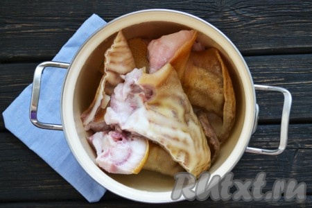 Свиные уши тщательно вымыть, разрезать на 2-3 части, вымыть и вычистить еще раз, особенно в труднодоступных местах. Обдать кипятком и выложить в кастрюлю, в которой будете варить холодец.
