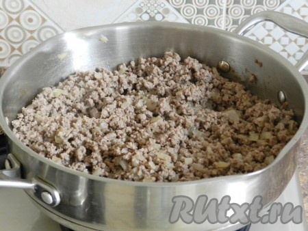 Обжаривать фарш с луком, постоянно перемешивая и разбивая комочки фарша, на небольшом огне.
