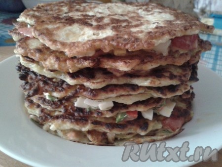 Каждый остывший блинчик смазать приготовленной начинкой. Сложить блинчики с начинкой друг на друга, формируя закусочный тортик.