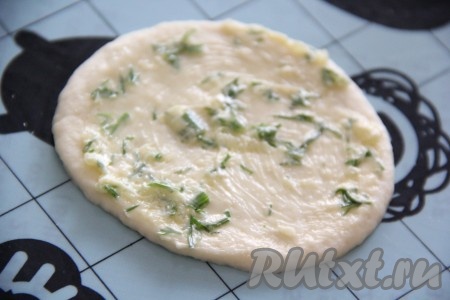 Слегка раскатать каждый кружок теста, затем смазать его частью чесночного масла.