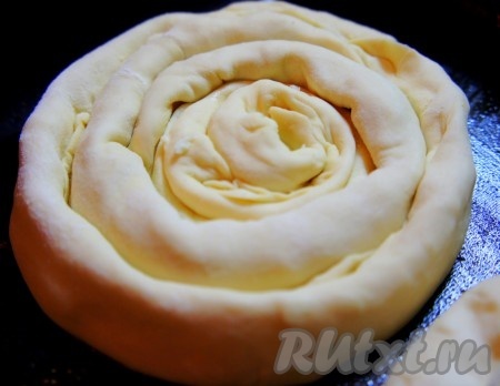 Форму для выпечки (или противень) смазать растительным маслом (или застелить пергаментом). На формирование каждой улитки потребуются 4 полоски с начинкой (то есть всего мы сформируем 2 улитки). Взять первую полоску с колбасой, свернуть её в улитку, вокруг неё по кругу обернуть полоску с сыром, затем вокруг обернуть полоску с колбасой, после этого обернуть полоску с сыром, получится улитка, как на фото. Аналогично сформировать вторую улитку. Сформированные улитки с колбасой и сыром выложить в подготовленную форму для выпечки (или на противень).