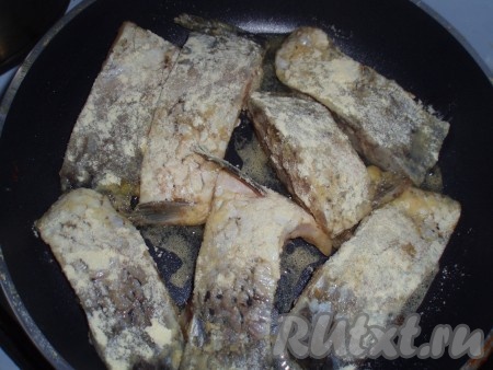 Выложить рыбу на сковородку, обжарить до румяной корочки с одной стороны,