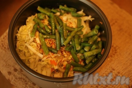 В форму от мультиварки выложить пекинскую капусту, морковь и фасоль, добавить соевый соус и натертый чеснок. Перемешать и поставить в мультиварку на 1 час на режим «Тушение».
