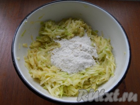 Получившуюся массу тщательно перемешать, всыпать соль, 2 столовых ложки муки, снова перемешать. Картофельно-кабачковое тесто для оладий должно получиться достаточно густым и вязким, сильно не растекаться в процессе жарки по сковороде. Если необходимо, можно добавить ещё 0,5-1 столовую ложку муки, перемешать.