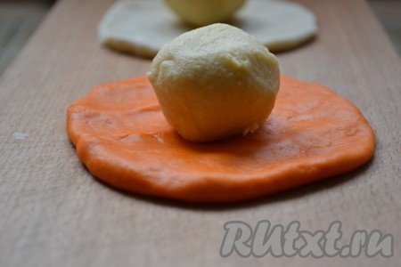 Получившееся белое и оранжевое тесто № 1 разделить на 6 равных частей (получится 6 кусочков оранжевого теста и 6 кусочков белого теста). Каждый из 12 кусочков теста № 1 раскатать в небольшую лепешку толщиной, примерно, 5 мм. У нас получится 6 лепёшек белого цвета и 6 лепёшек оранжевого цвета. Тесто № 2 достать из холодильника, разделить на 12 равных частей и каждую часть скатать в шарик. В центр каждой раскатанной лепешки положить по шарику из теста № 2, как на фото.
