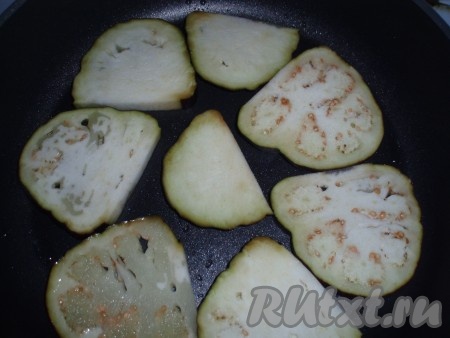 Баклажаны нарезать ломтиками, посолить и обжарить на разогретом растительном масле с двух сторон до золотистого цвета. Выложить обжаренные ломтики на бумажные полотенца, чтобы удалить избыток масла.
