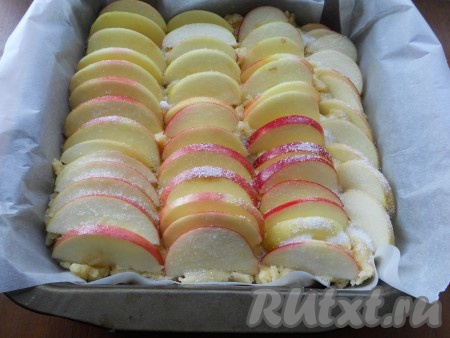 Из яблок удалить сердцевину, нарезать тонкими полукружками. Разместить яблоки вертикально (рядочками) на тесто, посыпать яблочки 2-3 столовыми ложками сахара. Поместить тесто с яблоками в разогретую до 180 градусов духовку на 20-25 минут.