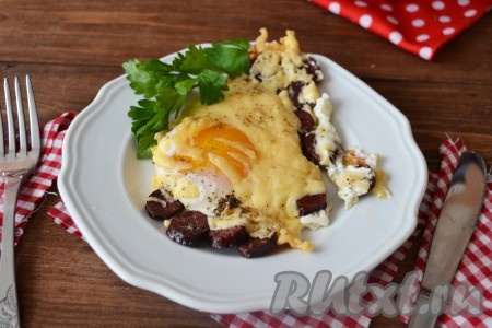 Перед подачей украсьте веточкой зелени. На стол необходимо подать сытную и вкусную яичницу с колбасой и сыром в теплом виде.
