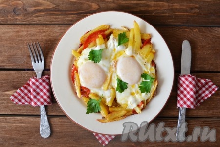 Вкусную, ароматную яичницу с хрустящей картошкой подать на стол в теплом виде, украсив листочками петрушки.
