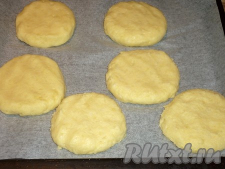 Из картофельной массы мокрыми руками сформировать небольшие лепёшки толщиной, примерно, 1,5 см. Выложить их на противень, застеленный пергаментом. 
