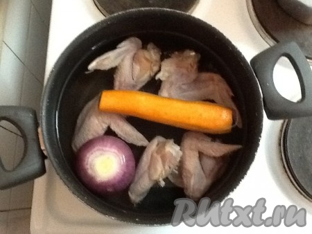 Варим бульон из куриных крылышек - складываем их в кастрюлю, заливаем водой, добавляем целую луковицу и морковь.