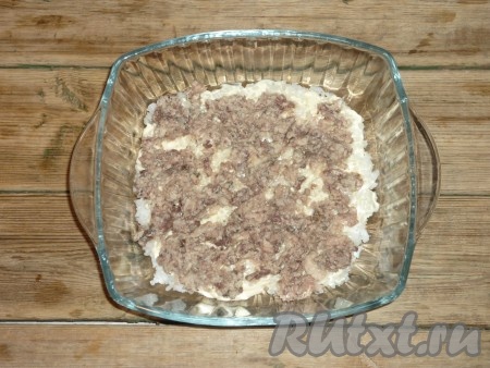 С консервов слить сок, а рыбу размять вилкой. Выложить половину консервов на рис. Разровнять.&nbsp;
