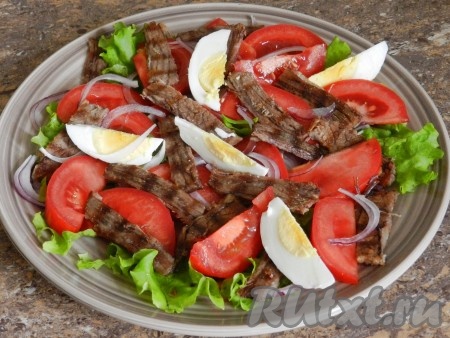 Яйца очистить, нарезать на четвертинки и добавить в салат из говядины, лука и помидоров. Посолить.
