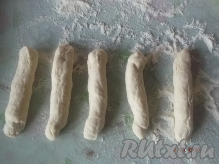 Получившиеся кубики теста растягиваем руками и скручиваем в жгутики.