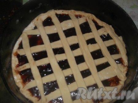 Раскатываем оставшееся тесто и вырезаем одинаковой ширины полоски. Выкладываем полоски крест на крест на сформированную форму с вареньем. Выпекаем пирог из теста на кефире с начинкой из варенья в разогретой духовке при температуре 160 градусов, примерно, 30 минут.
