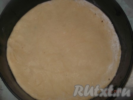 Разделяем тесто на две части. Одну часть раскатываем толщиной примерно 2 сантиметра и выкладываем на дно формы, предварительно смазанной маслом.
