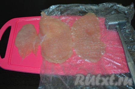 Каждую куриную грудку разрезать на 2 части. Каждую получившуюся часть куриного филе нарезать не толстыми пластами (примерно на 3 части). Каждый пласт слегка отбить молотком с двух сторон через целлофановый пакет.
