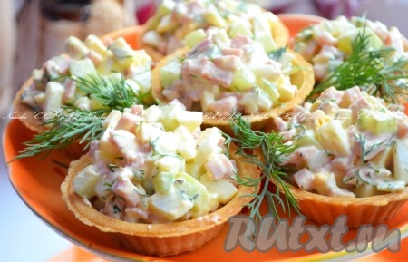 Заполнить тарталетки аппетитным, вкусным салатом с ветчиной и огурцами, украсить зеленью и можно подавать яркую закуску к столу.