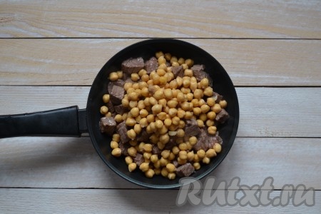 Всыпать к говядине нут и, помешивая, продолжить обжаривать еще минут 5.
