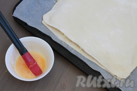 Второй пласт теста тоже раскатать до толщины 3 сантиметра. Раскатанным тестом накрыть тесто с начинкой, скрепить края пирога. Смазать пирог слегка взбитым сырым яичным желтком.