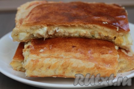 Готовую выпечку достать из духовки, дать немного остыть, а после этого можно нарезать на кусочки и подавать к столу. Вот так просто и быстро можно приготовить наивкуснейший пирог из слоёного теста с сочной, насыщенной начинкой из консервированной горбуши, сыра и яиц.