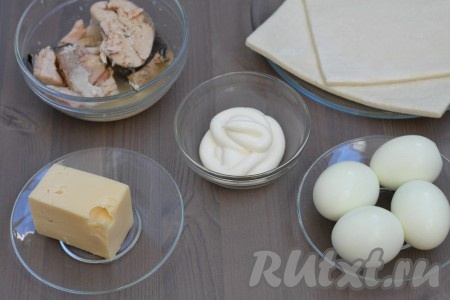 Подготовить продукты. Слоёное тесто можно взять как дрожжевое, так и бездрожжевое (я использовала слоёное дрожжевое тесто). Достать слоёное тесто из морозилки, разморозить его при комнатной температуре. У меня тесто было в 2 пластах. Яйца отварить в течение 10 минут с момента закипания воды, затем воду слить. Дать яйцам остыть. Консервированную горбушу без масла, в котором она находилась в банке, переложить в миску.