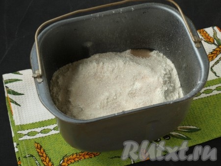 Просеять муку, затем сверху рассыпать дрожжи и притрусить их сахаром.
