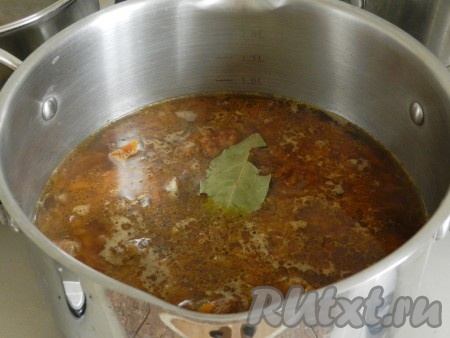 Затем переложить говядину с морковью и луком в кастрюлю с толстым дном, залить горячей водой так, чтобы покрывала мясо. Довести до кипения, добавить соль, перец, лавровый лист, накрыть крышкой и готовить на медленном огне 40-50 минут до мягкости мяса.