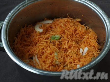 В кастрюлю с толстым дном налить подсолнечное масло, затем поочерёдно выложить все овощи: сначала помидоры, затем перец, лук и в конце морковь.
