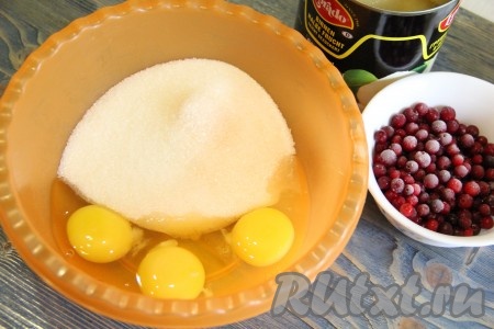 Подготовить продукты для приготовления пирога с яблоками и брусникой в духовке. Если используете замороженную бруснику, тогда размораживать её не нужно. Свежие ягоды нужно промыть водой, затем выложить в дуршлаг, чтобы стекла вода. В глубокой миске соединить яйца и сахар.