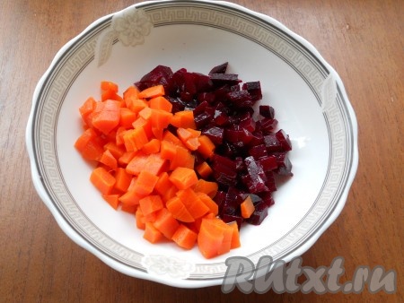 Картофель, свеклу и морковь очистить. Свеклу нарезать небольшими кубиками, влить подсолнечное масло и перемешать. Добавить морковь, нарезанную кубиками.
