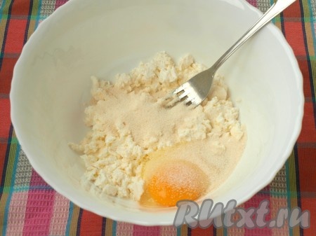 В мисочке размять творог при помощи вилки. Добавить манную крупу и вбить яйцо.
