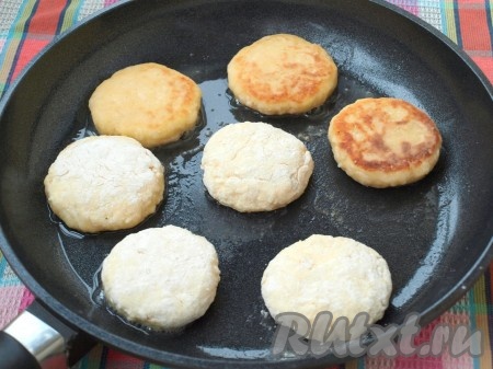 Разогреть сковороду, влить и нагреть масло. Выложить подготовленные заготовки сырников и обжарить до румяной корочки. Затем перевернуть и обжарить с другой стороны.
