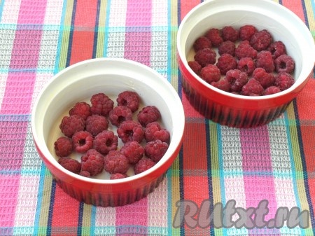 Порционные формочки смазать сливоным маслом. На дно выложить сухие ягоды малины.