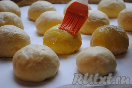 Яйцо взбить вилкой и силиконовой кисточкой смазать булочки.&nbsp;
