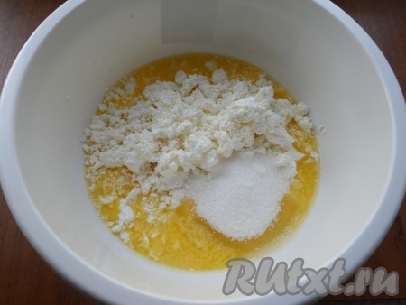 Масло сливочное растопить, немного остудить, переложить в объёмную миску, затем всыпать 2 столовые ложки сахара, ванильный&nbsp;сахар, добавить творог.