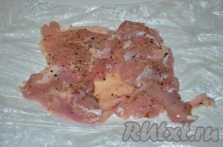 Начинаем готовить блюдо с разделки курицы. Для этого сначала нужно обрезать крылья. Положить курицу на спинку, разрезать по середине грудки и отогнуть обе части в стороны. И постепенно отделять мясо от костей. Ножки оставляем, разделываем, а грудку я вообще обрезала и убрала, ее не используем. Осталось одно мясо с кожей, которое я разрезала на 2 части размером примерно 18х18 см (для двух рулетов). Каждую часть посолить, поперчить.