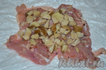 На каждую часть мяса с кожей выложить грибы и пропущенный через пресс чеснок.
