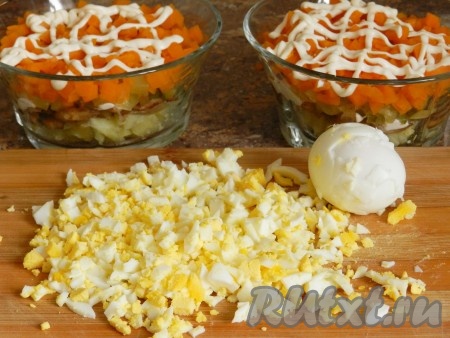 На морковь также нанести сетку из майонеза. Я не люблю салаты, утопающие в майонезе, поэтому наношу сетку с помощью маленького пакетика и не промазываю майонезом каждый слой. Яйца очистить, нарезать на небольшие кубики.