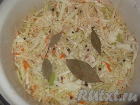 Добавляем в капусту с морковью горошины черного перца, лавровый лист, хорошо мнем капусту руками, а потом заливаем рассолом.