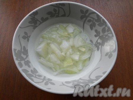 Теперь замаринуем лук. Для этого 100 миллилитров очень горячей воды нужно влить в глубокую тарелку, добавить сахар и соль, тщательно перемешать, влить уксус, снова перемешать получившийся маринад. Очищенный лук, нарезанный тонкими четвертинами (или полукольцами), выложить в горячий маринад, перемешать и оставить на 10 минут.