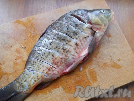 Карпа очистить от чешуи, удалить внутренности и жабры, хорошо вымыть. Сделать надрезы около хребта с двух сторон.