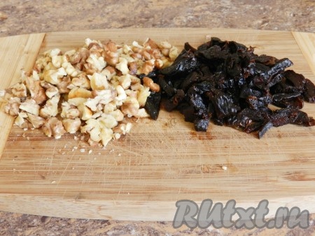 Орехи порубить ножом, чернослив нарезать кусочками. Если чернослив слишком сухой, предварительно размочите его в кипятке, а затем обсушите и нарежьте.
