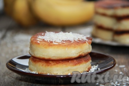 Подать пышные, вкусные и ароматные сырники к столу. Можно полить их сгущёнкой и посыпать кокосовой стружкой. 
