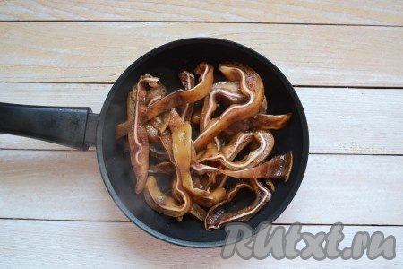 На разогретую сковороду влить масло и через минуту выложить уши. Периодически помешивая, обжарить 2 минуты. Влить половину соуса, в котором мариновались свиные уши, и продолжить обжаривать еще 10-15 минут, иногда перемешивая. За это время должна выпариться вся жидкость со сковороды, а сами ушки поджарятся до красивого румяного цвета.
