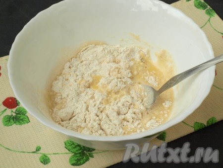 Добавить в получившуюся смесь просеянную муку вместе с разрыхлителем, а также соль и ванильный сахар, хорошо перемешать тесто ложкой.
