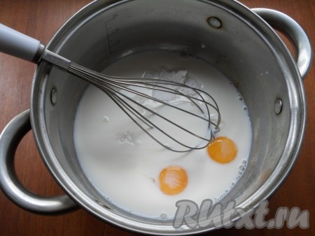 В кастрюлю влить молоко, добавить крахмал и сырые желтки.
