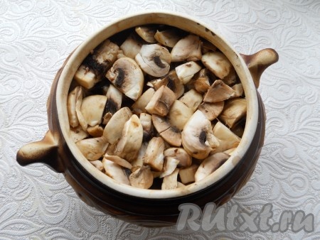 В горшочек поверх свинины с овощами выложить шампиньоны, немного утрамбовать.