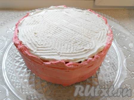 Дальше выровнять бока и верх торта толстым слоем крема, я для этих целей делаю мокрое безе. Для приготовления мокрого безе я к 3 белкам добавила 150 грамм сахара, 0,5 пакетика ванильного сахара и 2 щепотки лимонной кислоты. Взбила немного миксером, а затем поместила на водяную баню, снизила огонь до минимума и взбивала крем в течение 10-15 минут до очень плотного состояния. Затем сняла с огня и взбивала еще около 5 минут - безе стало плотным и стойким. После этого охладила крем в прохладном месте. В этот раз бока торта я смазала, добавив в крем розовый краситель, а верх - белым кремом.
